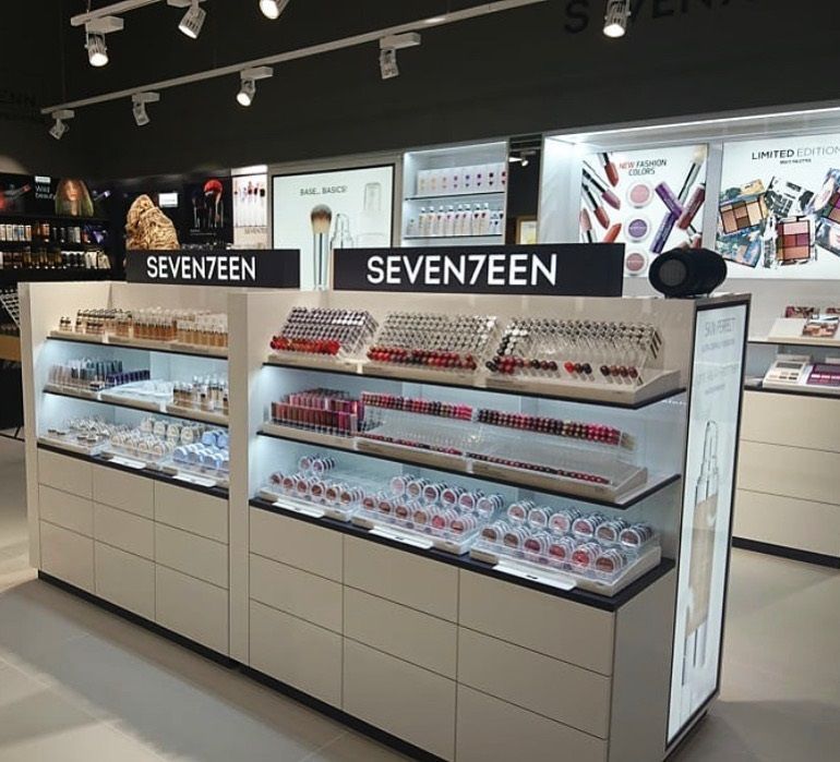 Makeup display with SEVENTEEN products in a store, featuring shelves with products and signage.
