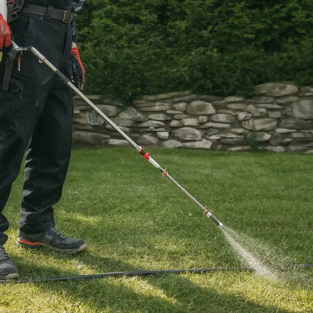 Technician applying professional weed control treatment to a residential lawn in Mesa, AZ Technician applying professional weed control treatment to a residential lawn in Mesa, AZ