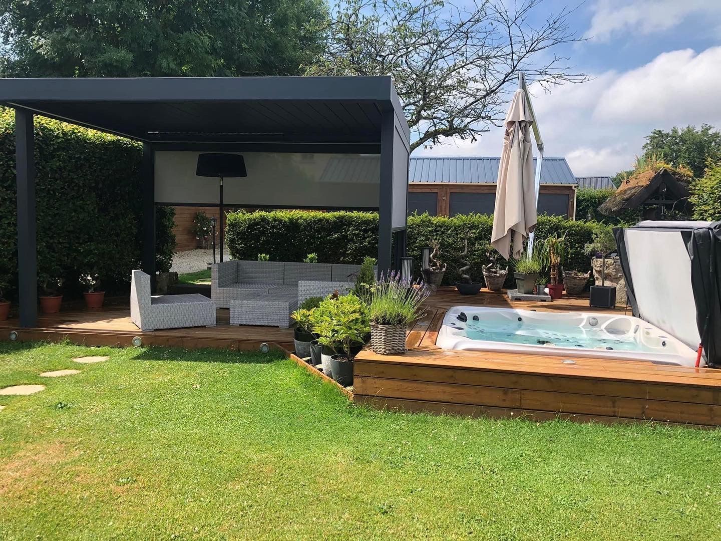 Une cour arrière avec un jacuzzi et une pergola.