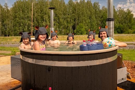 Un groupe de personnes est assis dans un bain à remous en bois.