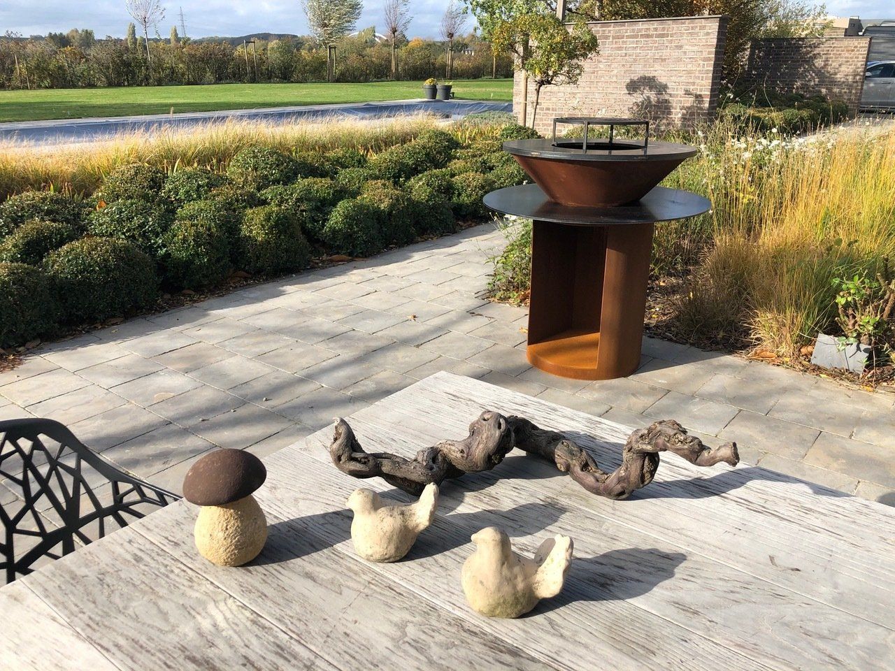 Une table avec des champignons et un grill dessus dans un jardin.