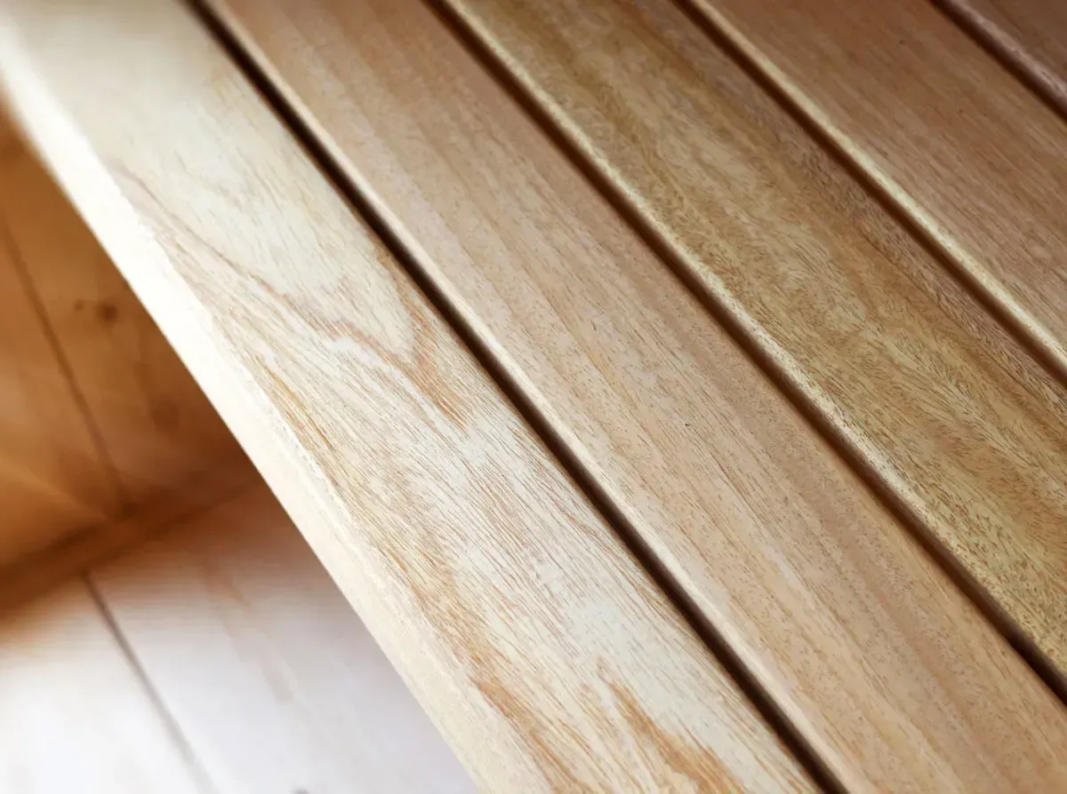 Un gros plan d'un morceau de bois d'un sauna sur un plancher en bois.