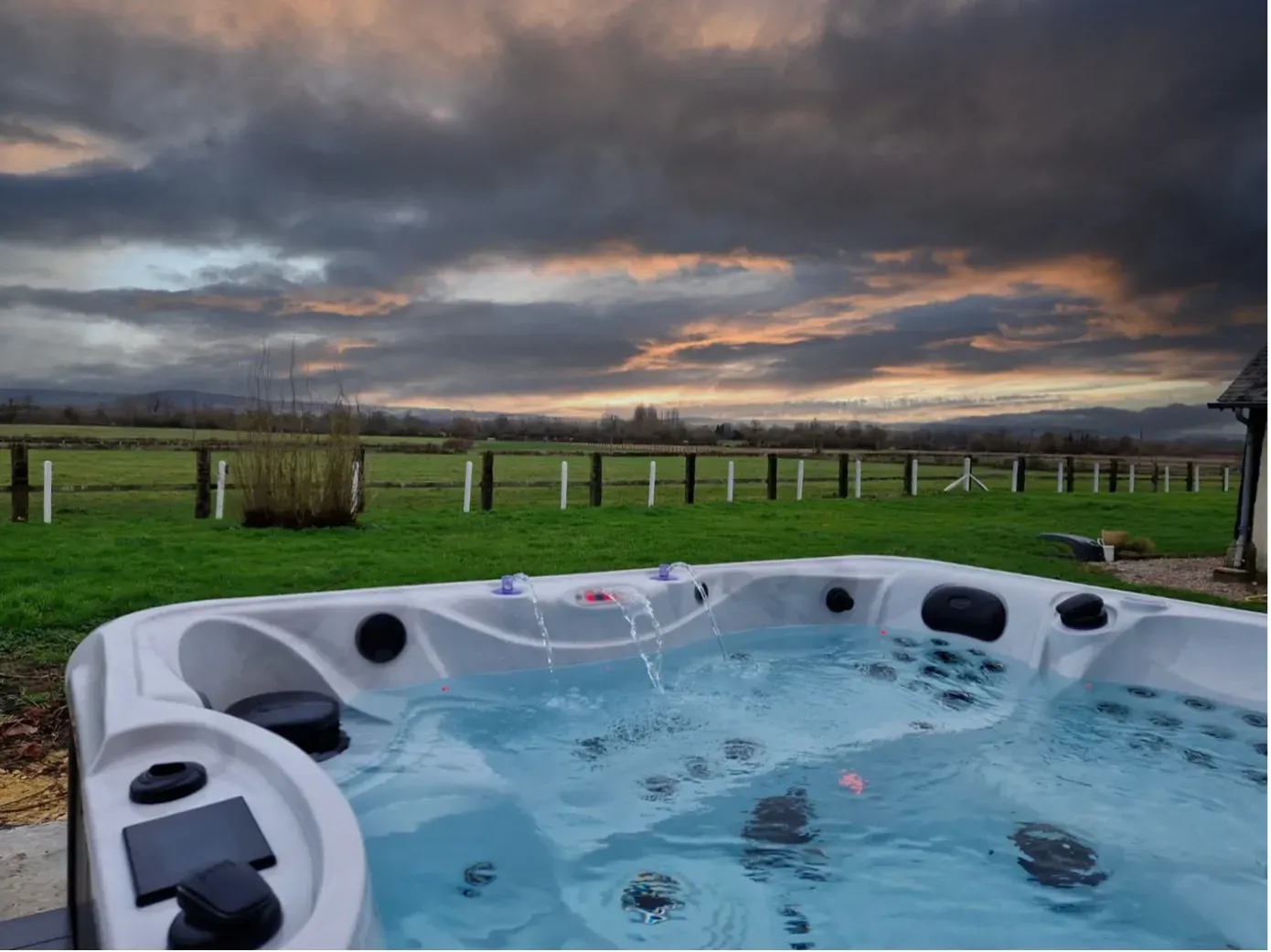 Un bain à remous est assis au milieu d'un champ herbeux.