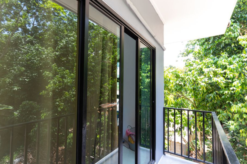 Sliding Glass Doors Open Onto a Balcony With Black Railing — Working Windows in Mullumbimby, NSW