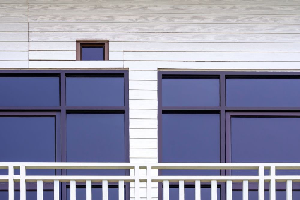 Blue-tinted Apartment Windows Above a White Balcony Railing — Working Windows in Sunshine Coast, QLD