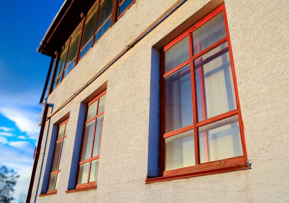 Exterior Wall With Red-trimmed Windows Against a Blue Sky — Working Windows in Noosa Heads, QLD