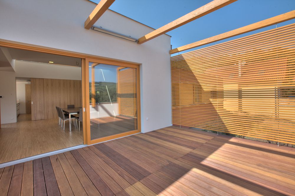 Wooden Patio With a Sliding Glass Door and Slatted Wood Screen on a Sunny Day — Working Windows in Byron Bay, NSW