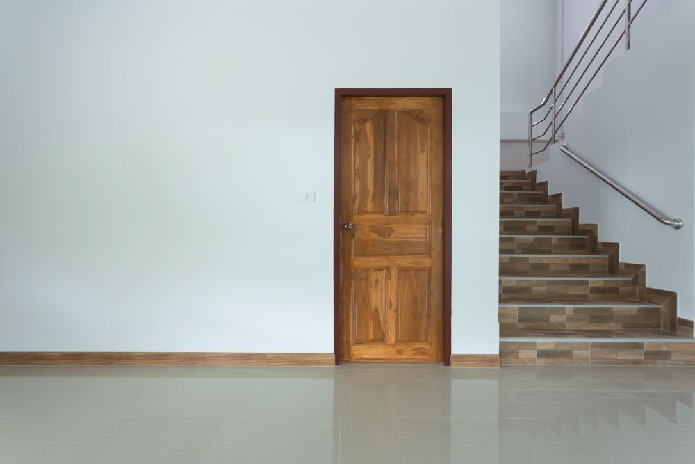 Wooden Door Between a White Wall and Staircase With Tiled Steps — Working Windows in Byron Bay, NSW
