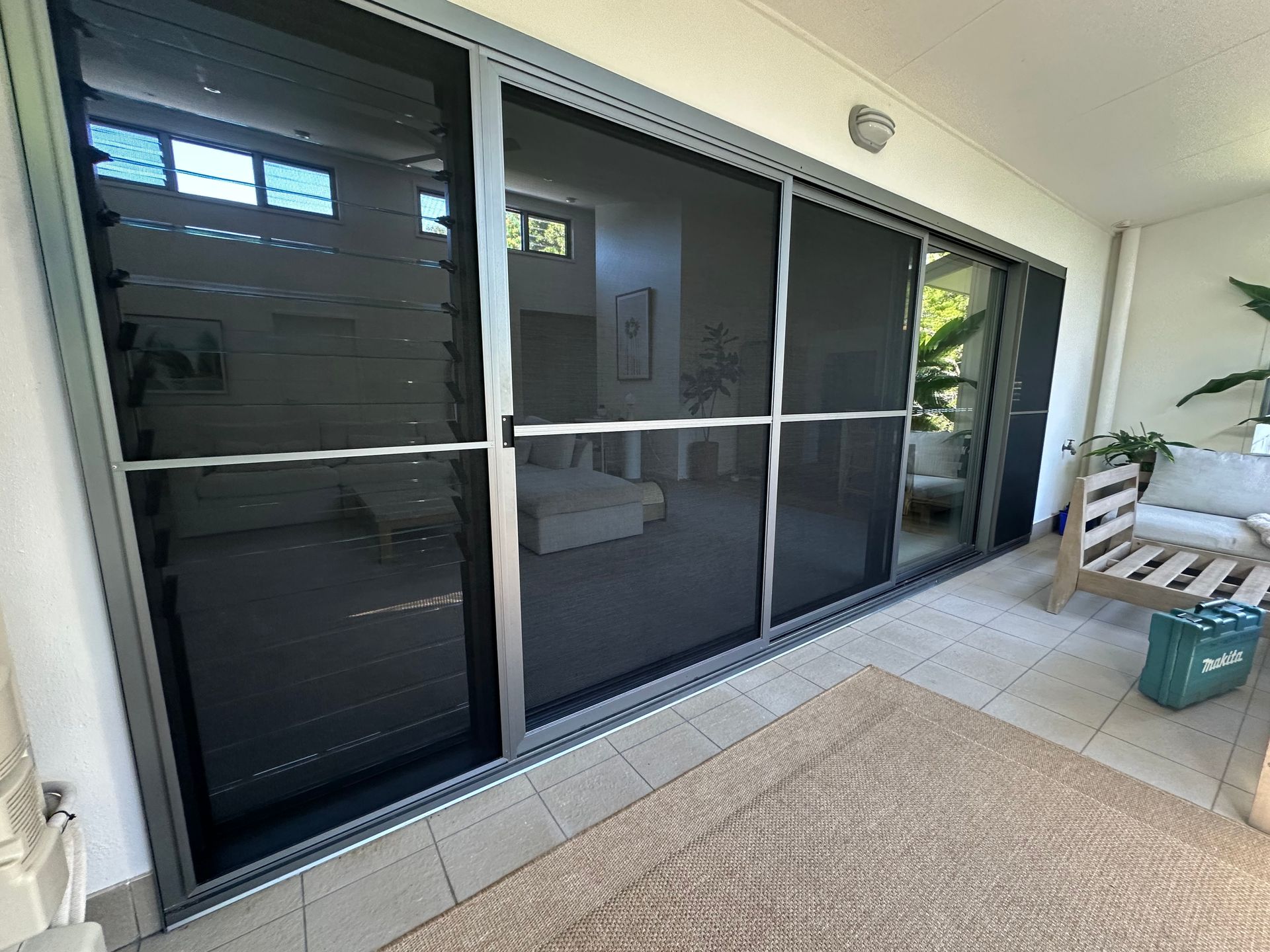 Sliding Glass Doors With Dark Screens Opening to a Tiled Patio — Working Windows in Sunshine Coast, QLD