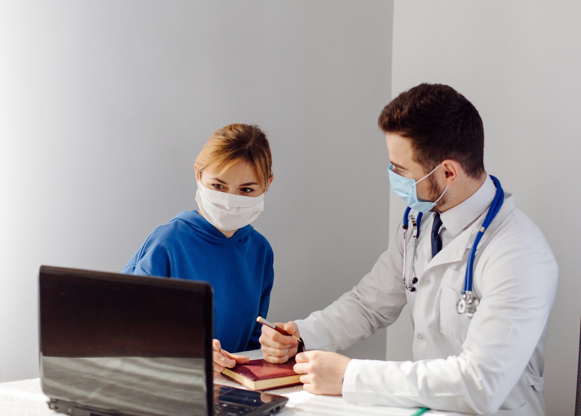 Un médico está hablando con un paciente que lleva una máscara.