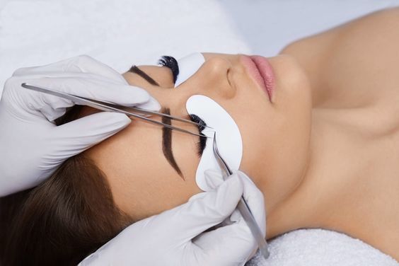 Una mujer se está haciendo las pestañas en un salón de belleza.