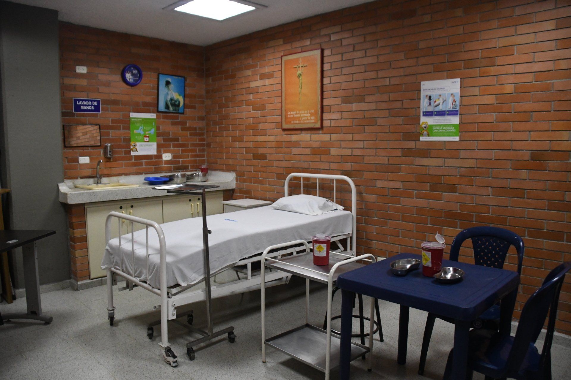 Una habitación de hospital con una cama, mesa y sillas.