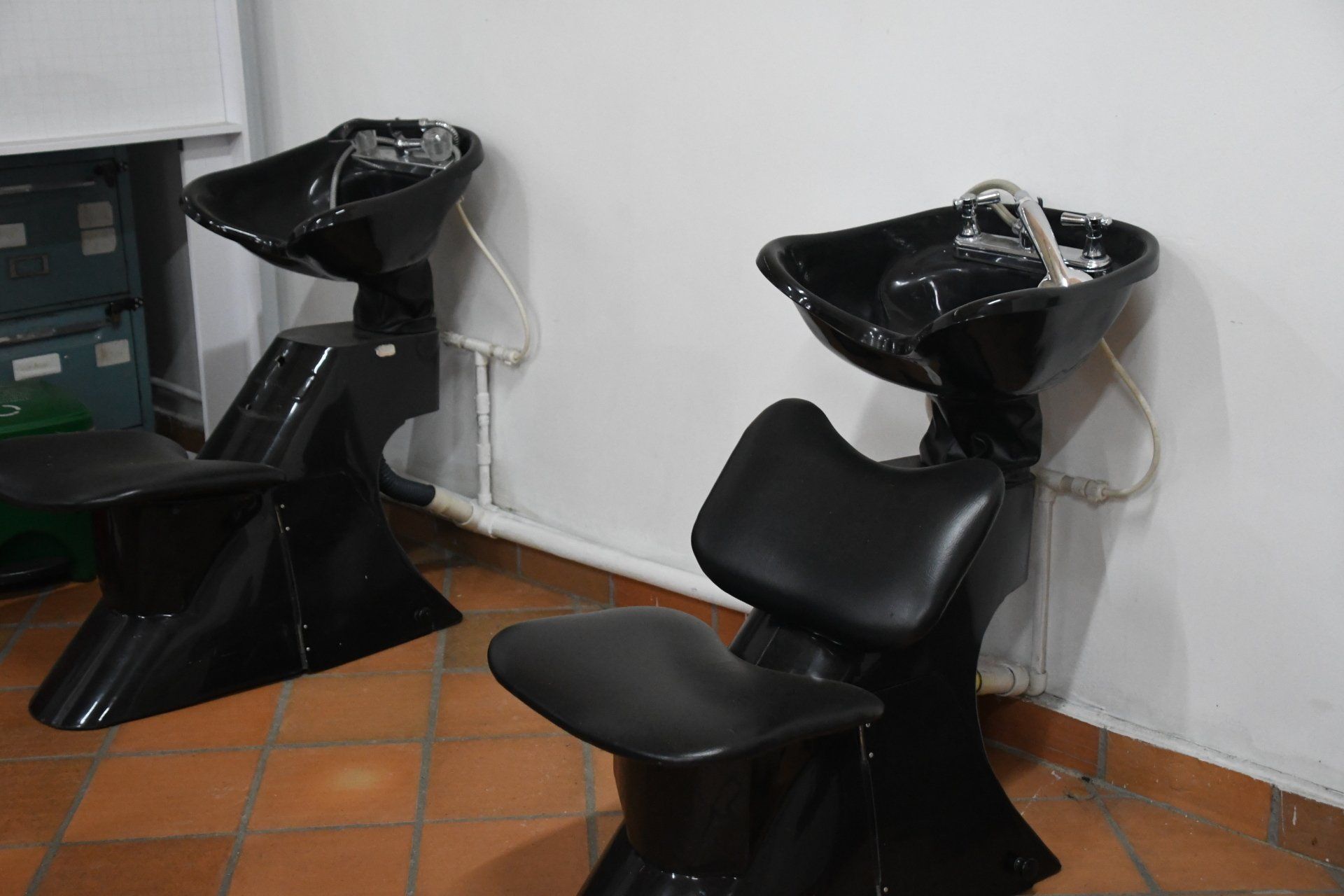 Dos sillas negras están una al lado de la otra en una habitación.