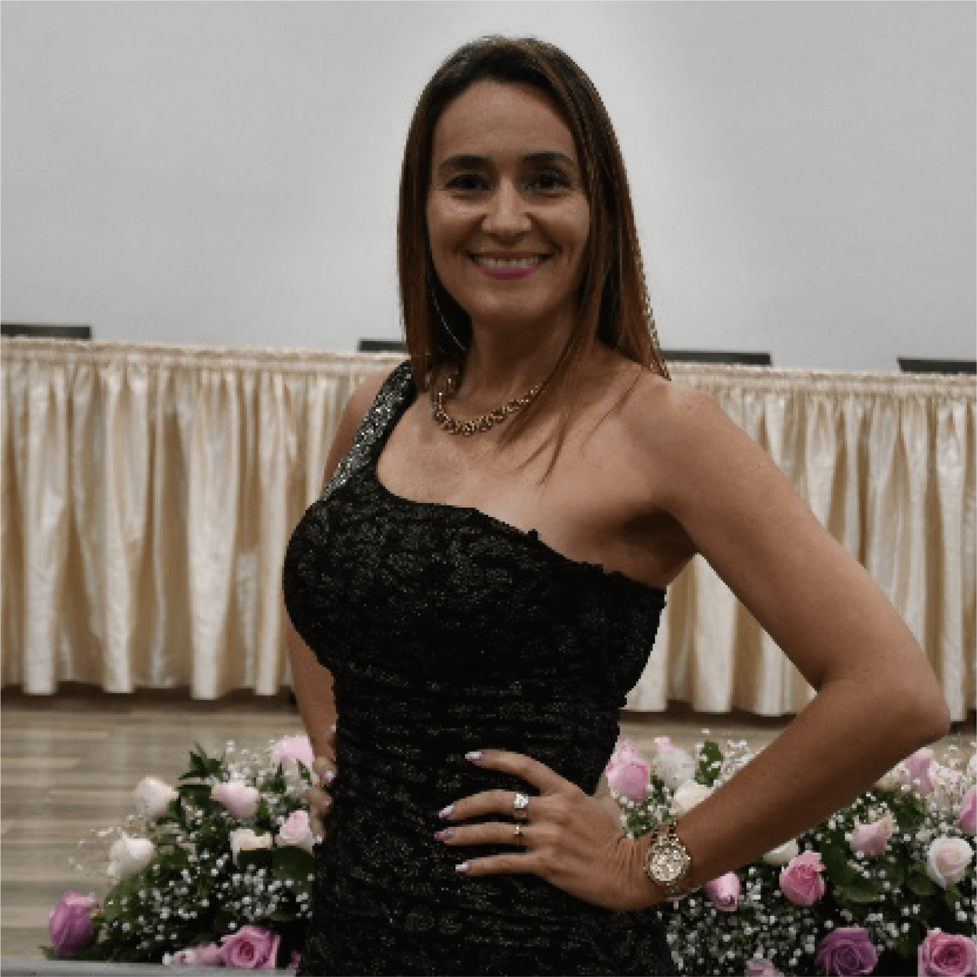 Una mujer con un vestido negro está de pie con la mano en la cadera.