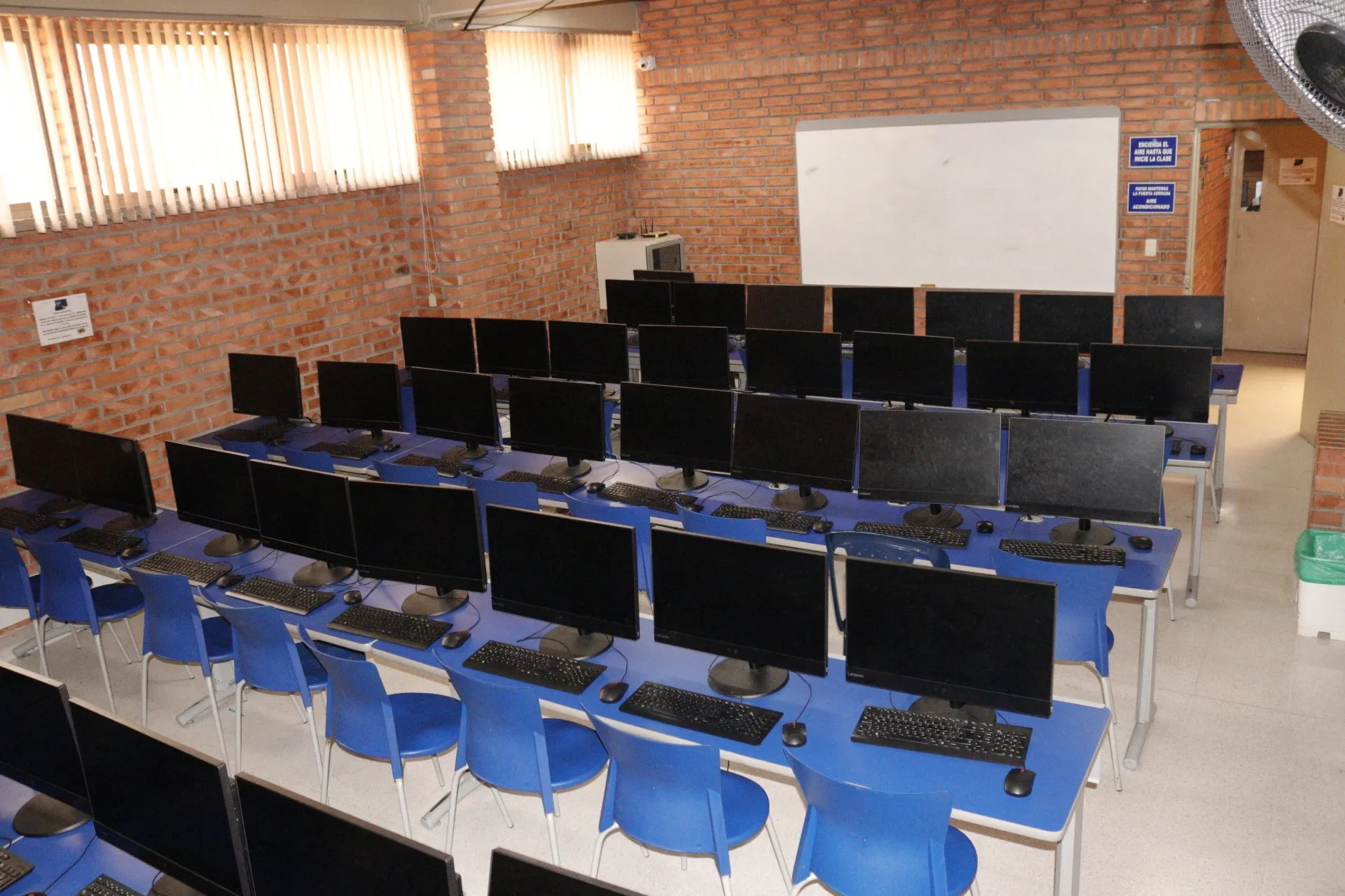 Una habitación llena de muchos monitores de computadora y teclados