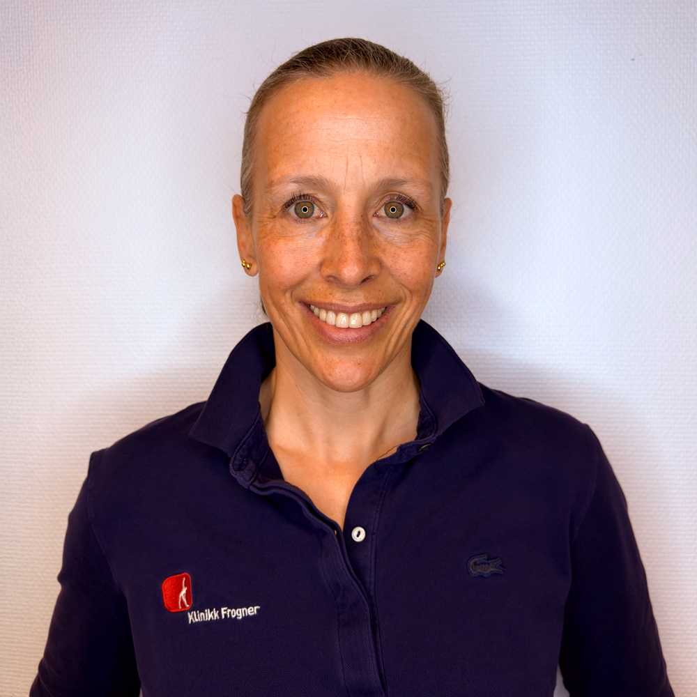 Kvinne som bokser i et treningsstudio og slår med en tung boksesekk. Hun har på seg hansker og sports, med fokusert uttrykk.