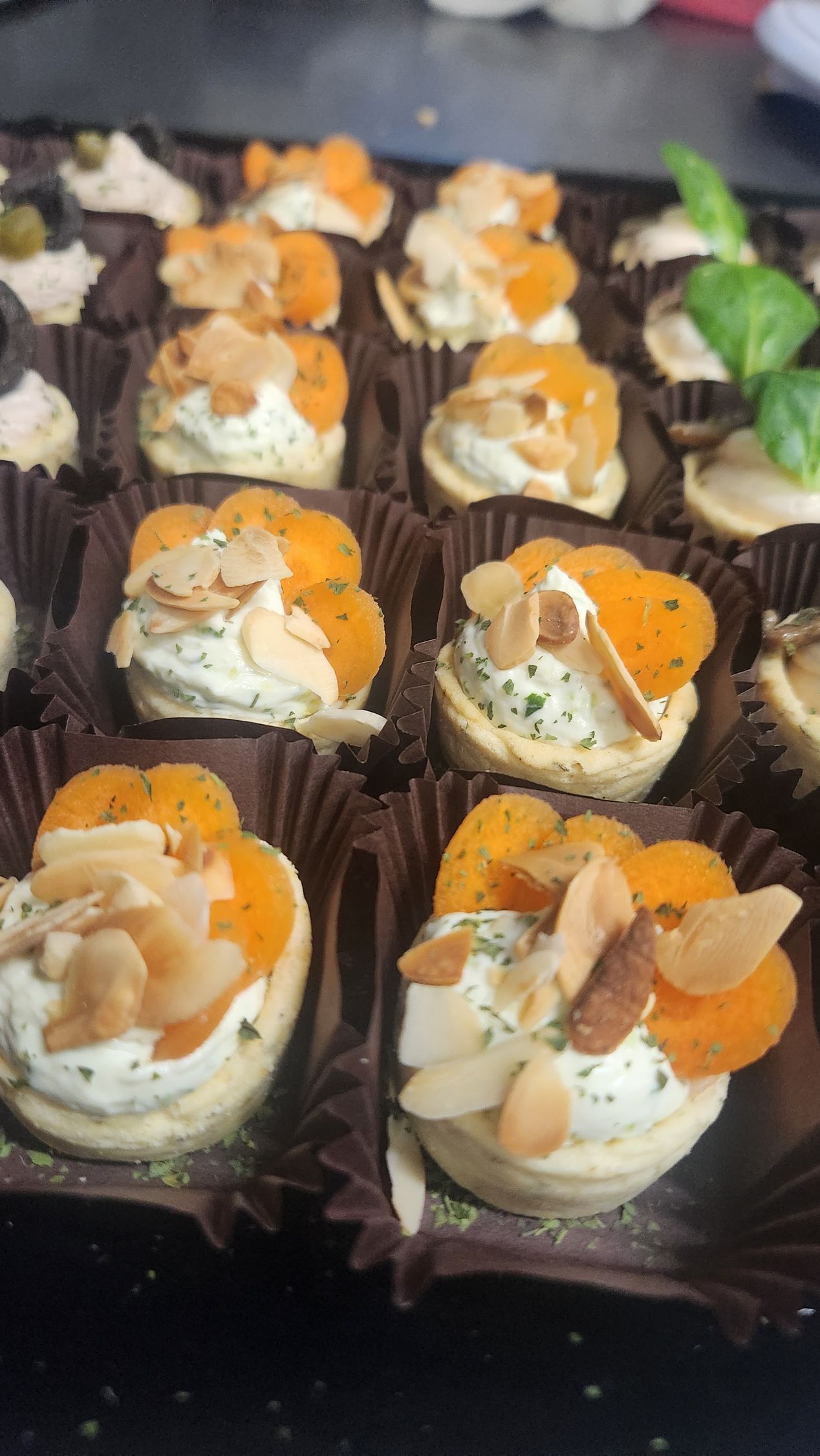 File di mini coppette da dessert con panna e guarnizione all'arancia su un vassoio