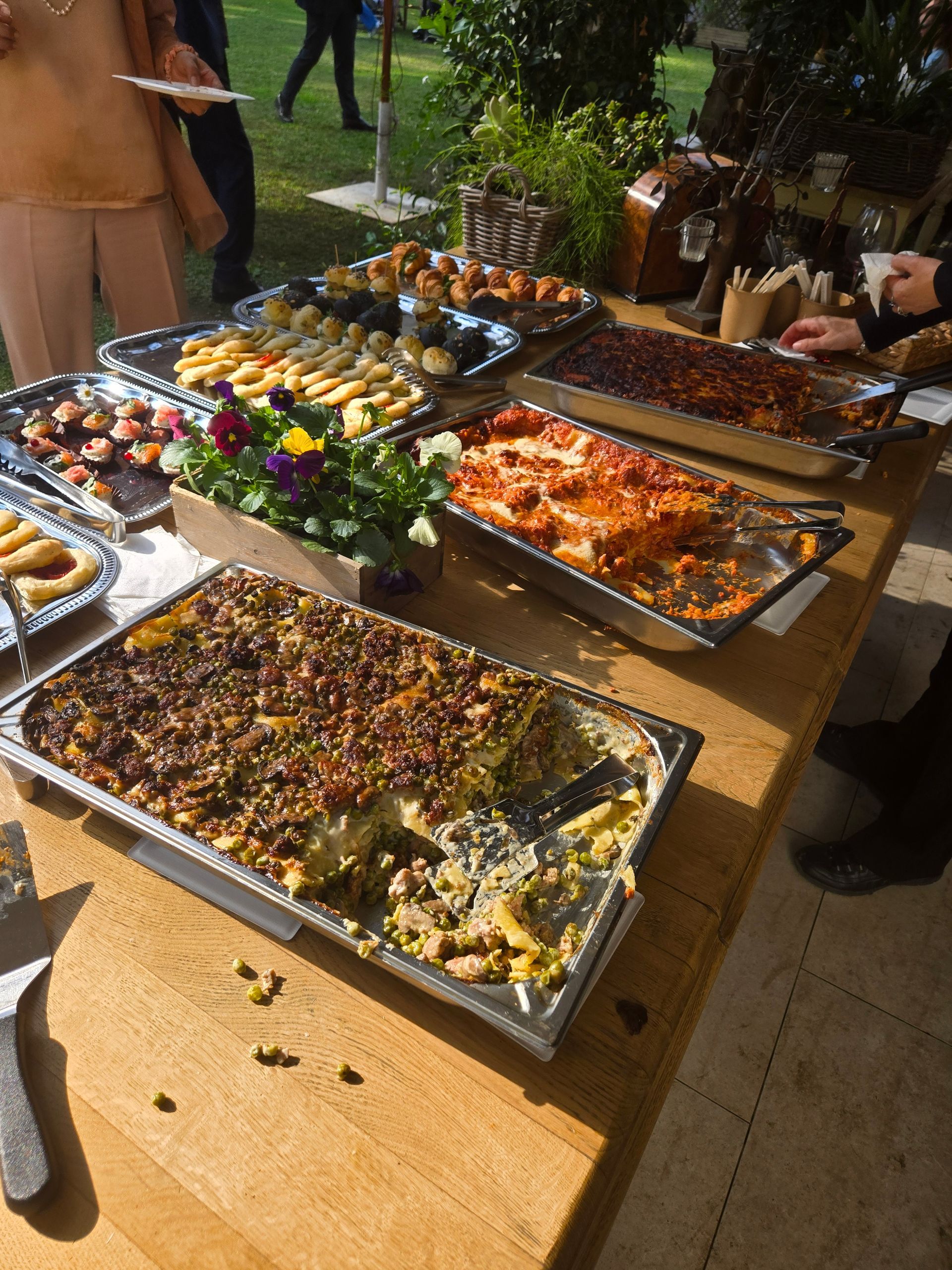 Tavolo da buffet all'aperto con assortimento di antipasti e vassoi di cibo colorato alla luce del sole