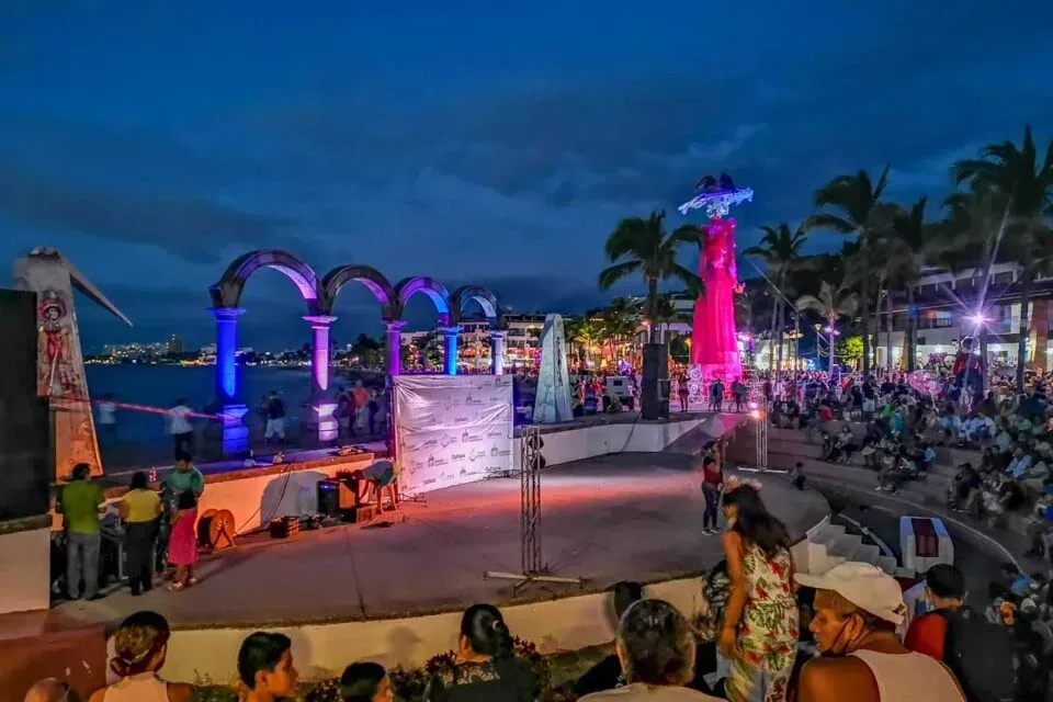 A group of people are sitting in front of a stage at night.