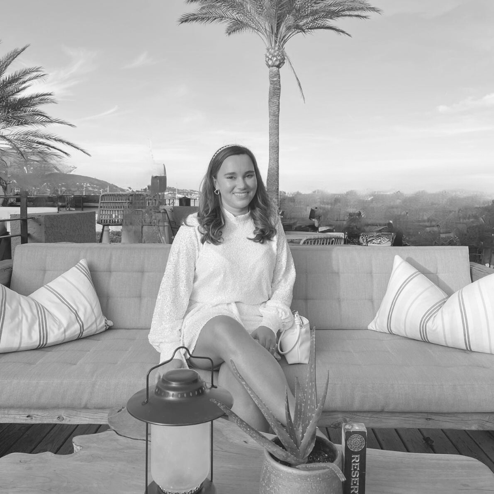 A woman is sitting on a couch in a black and white photo.
