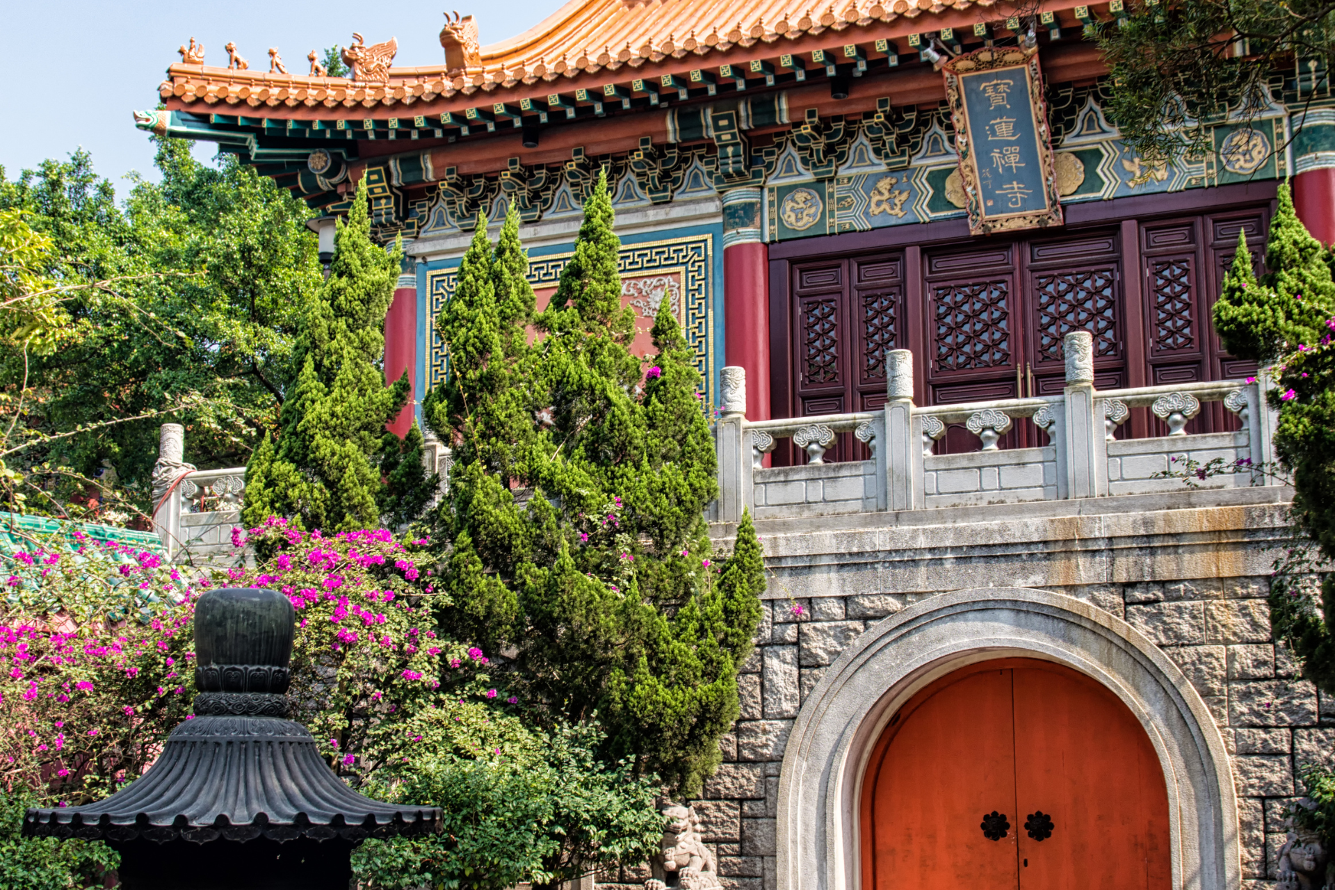 A chinese building with a red roof and a wooden door