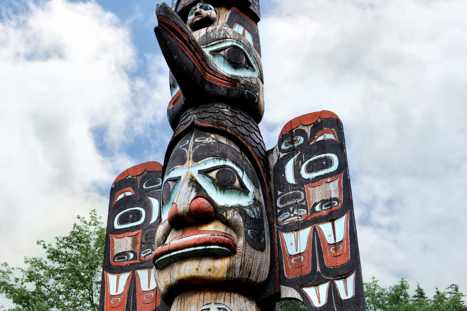 A close up of a totem pole with a face on it.