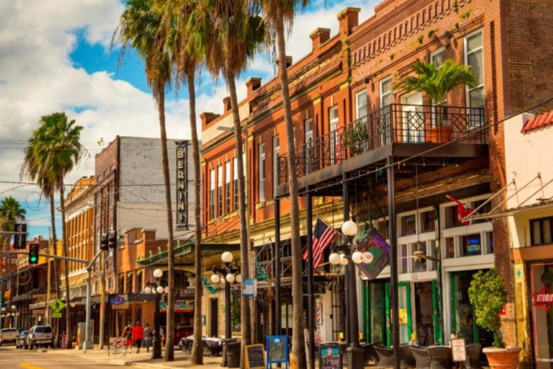 A city street with a lot of buildings and palm trees.