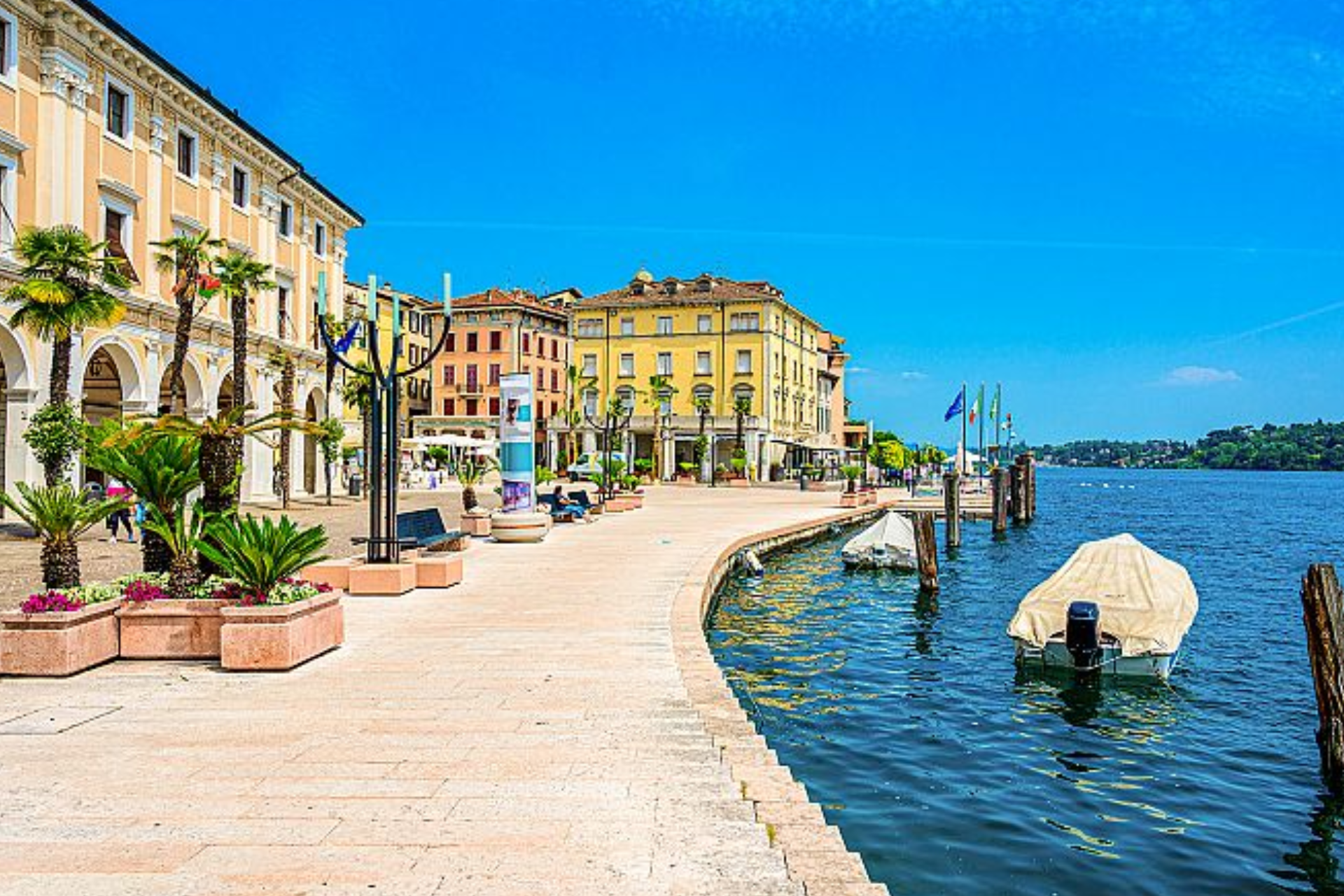 A row of buildings next to a body of water with a boat in the water.