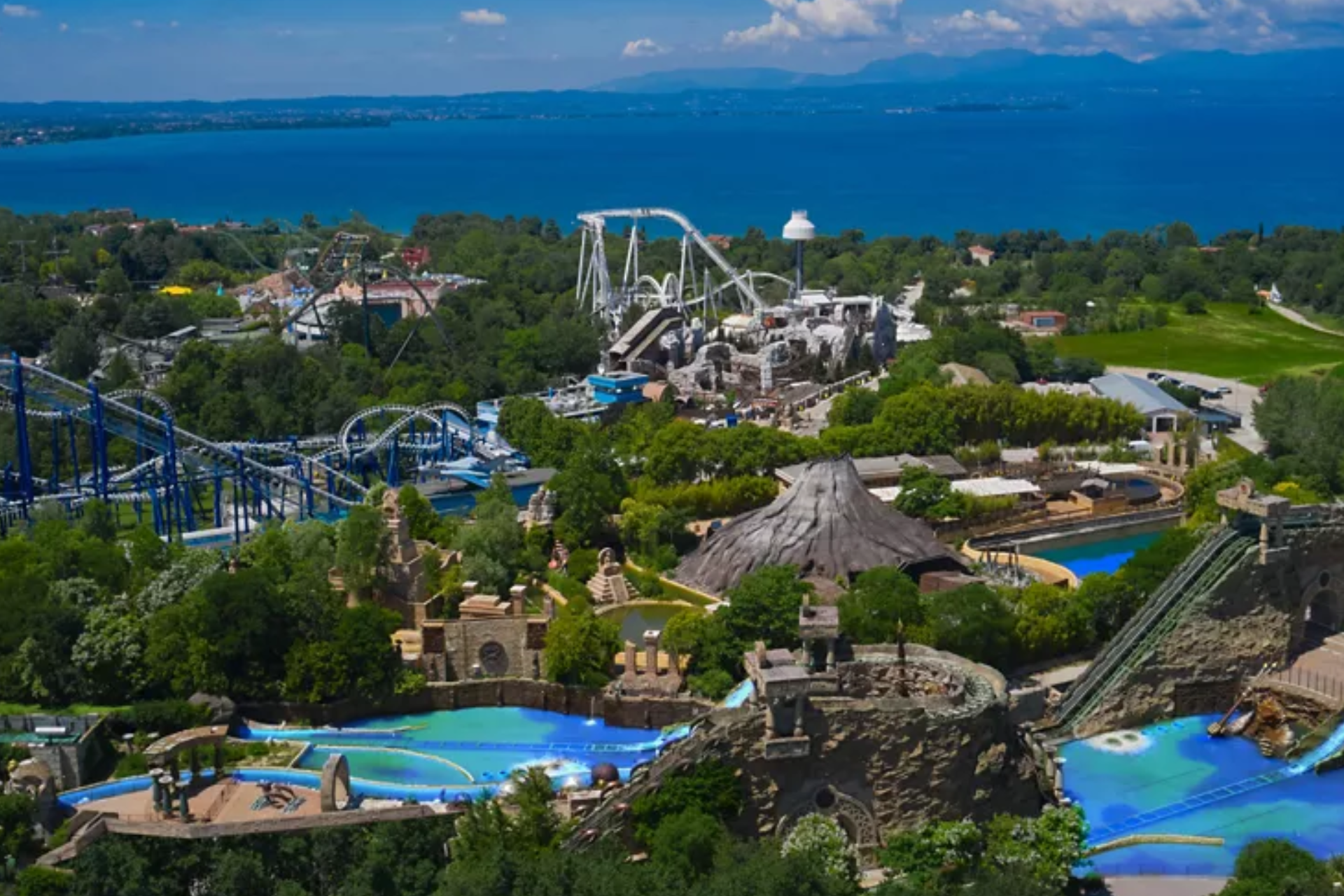 An aerial view of a theme park surrounded by trees and water.