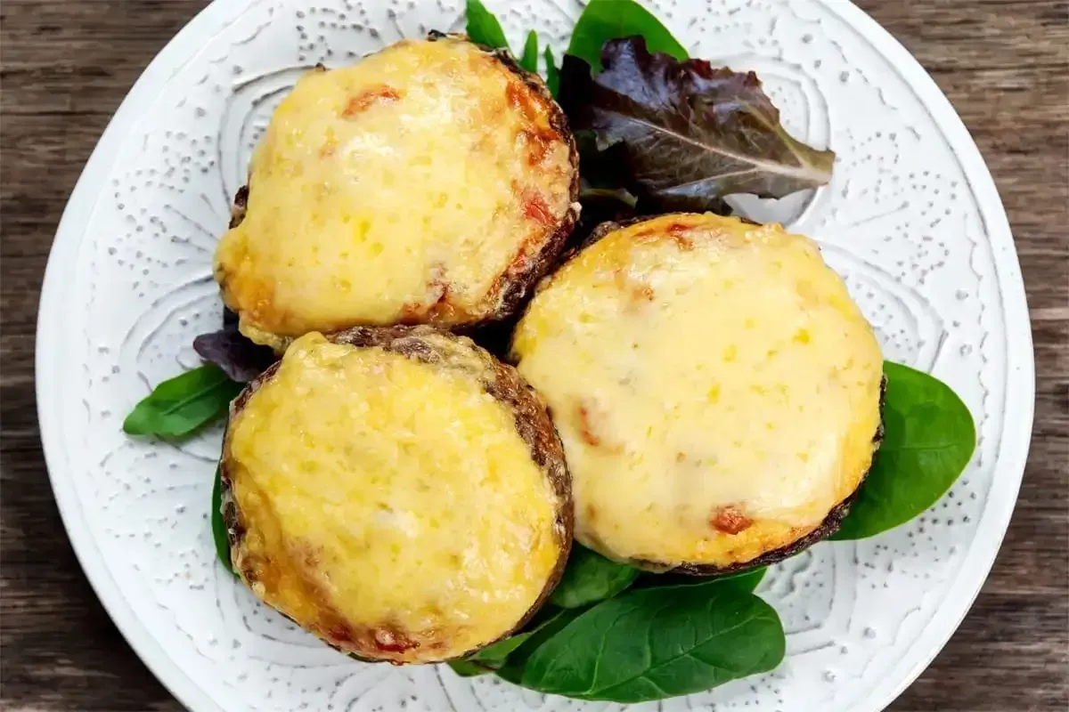 A plate of food with cheese and lettuce on a wooden table.