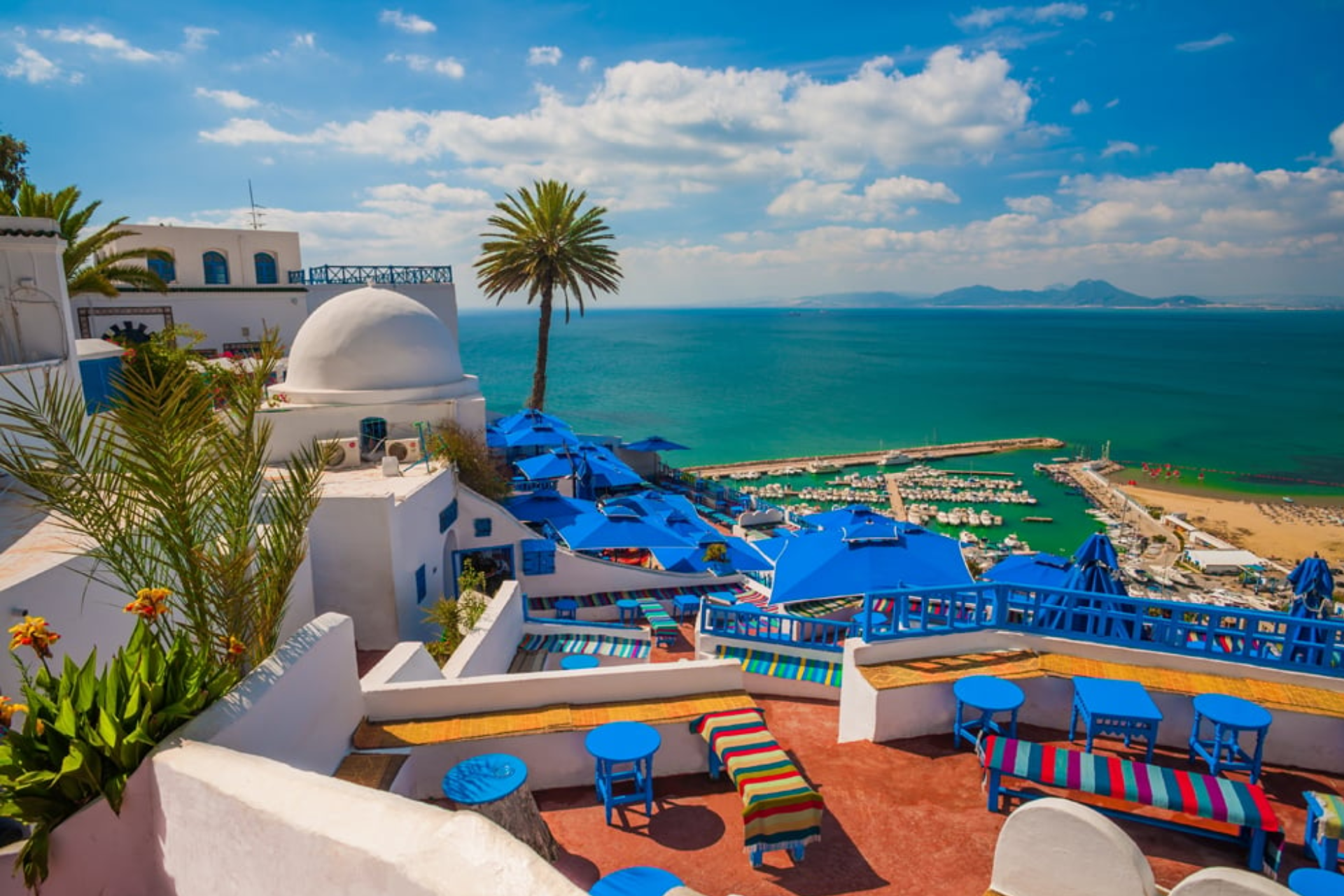 A view of a city from a balcony overlooking the ocean.