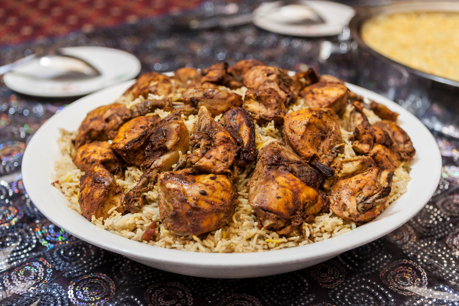 A white bowl filled with rice and chicken on a table.