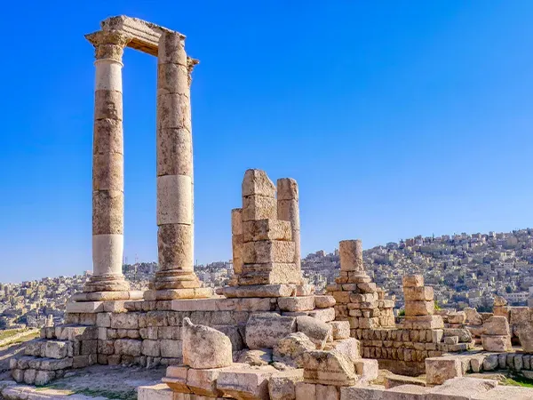 A group of ancient columns sitting on top of a hill.