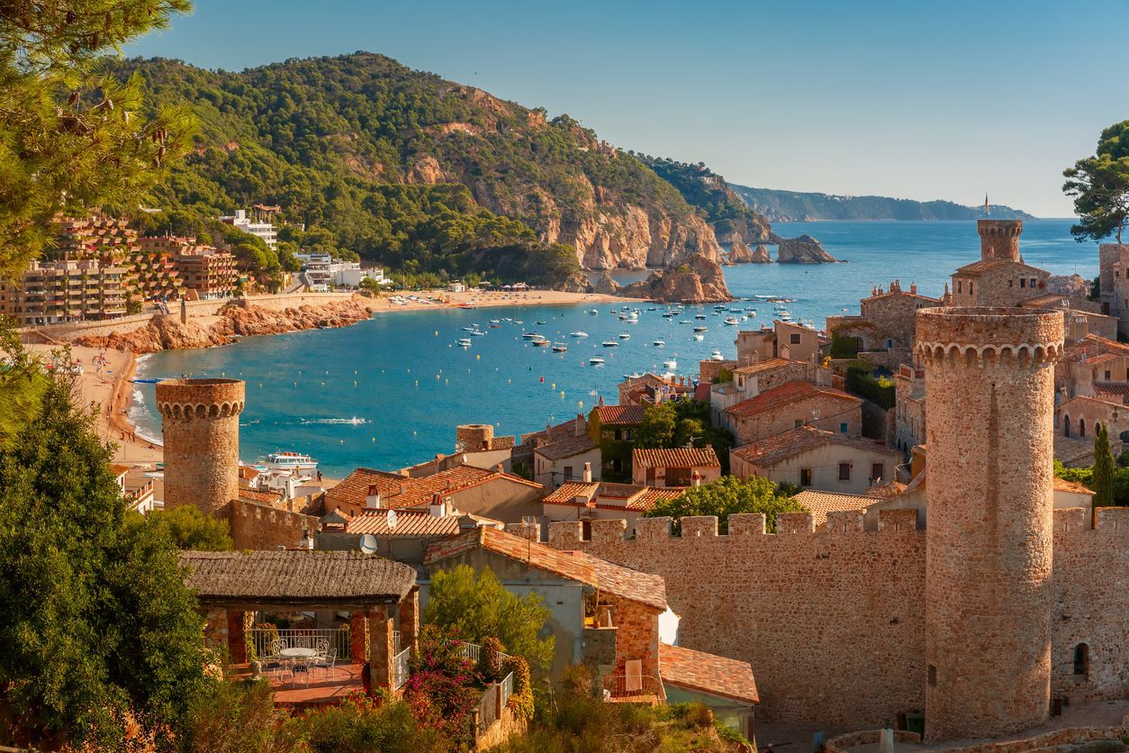 There is a castle in the foreground and a city in the background.