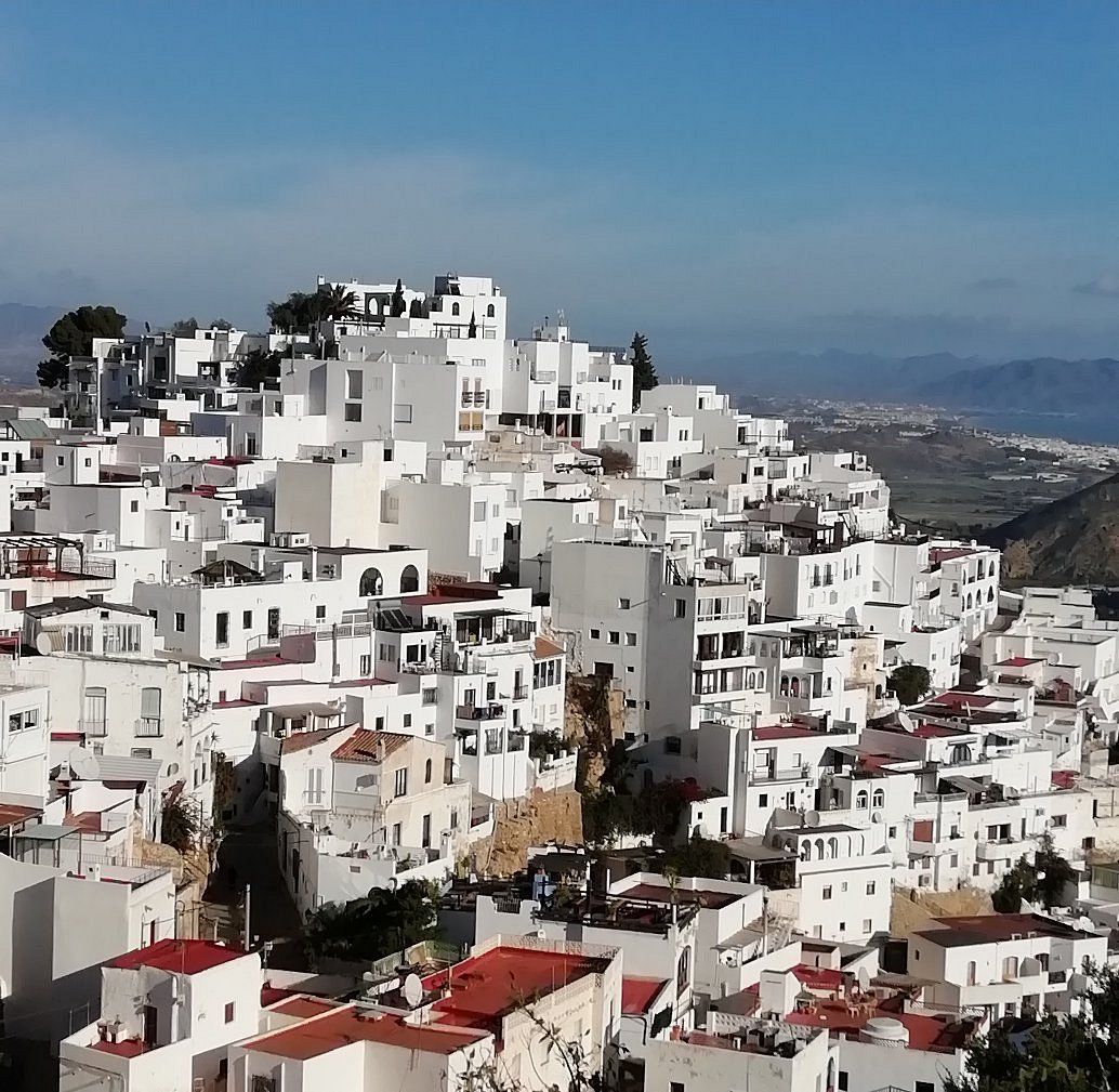 A city on top of a hill with lots of white buildings