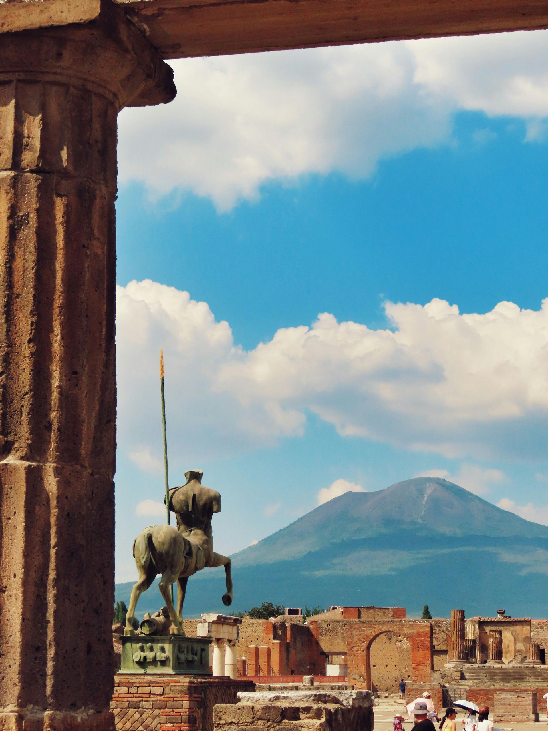 A statue of a man on a horse with a mountain in the background