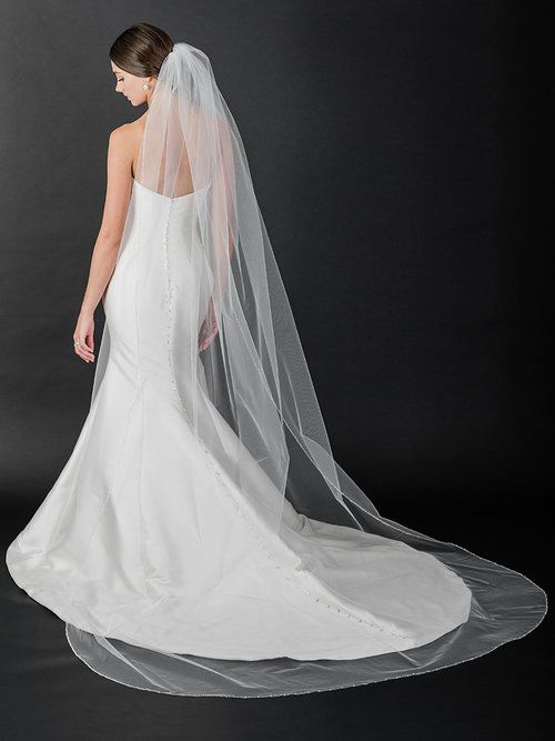 A woman in a wedding dress is standing on a beach.