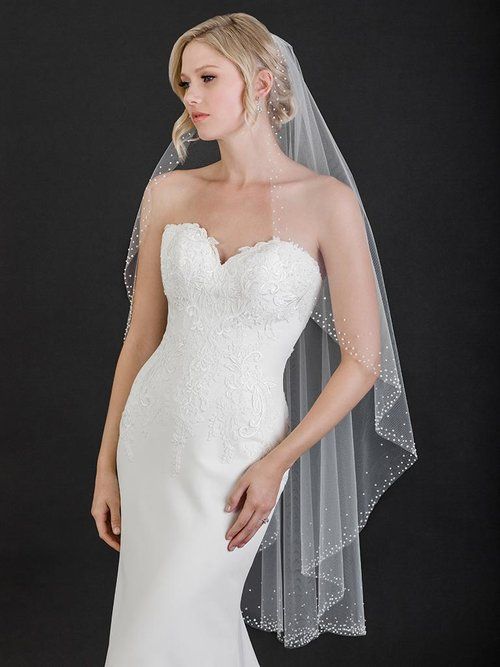 A woman in a wedding dress is wearing a veil