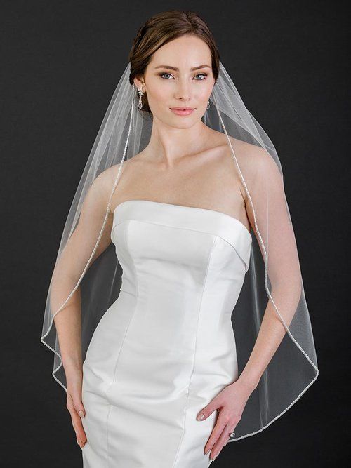 A woman in a wedding dress is wearing a veil