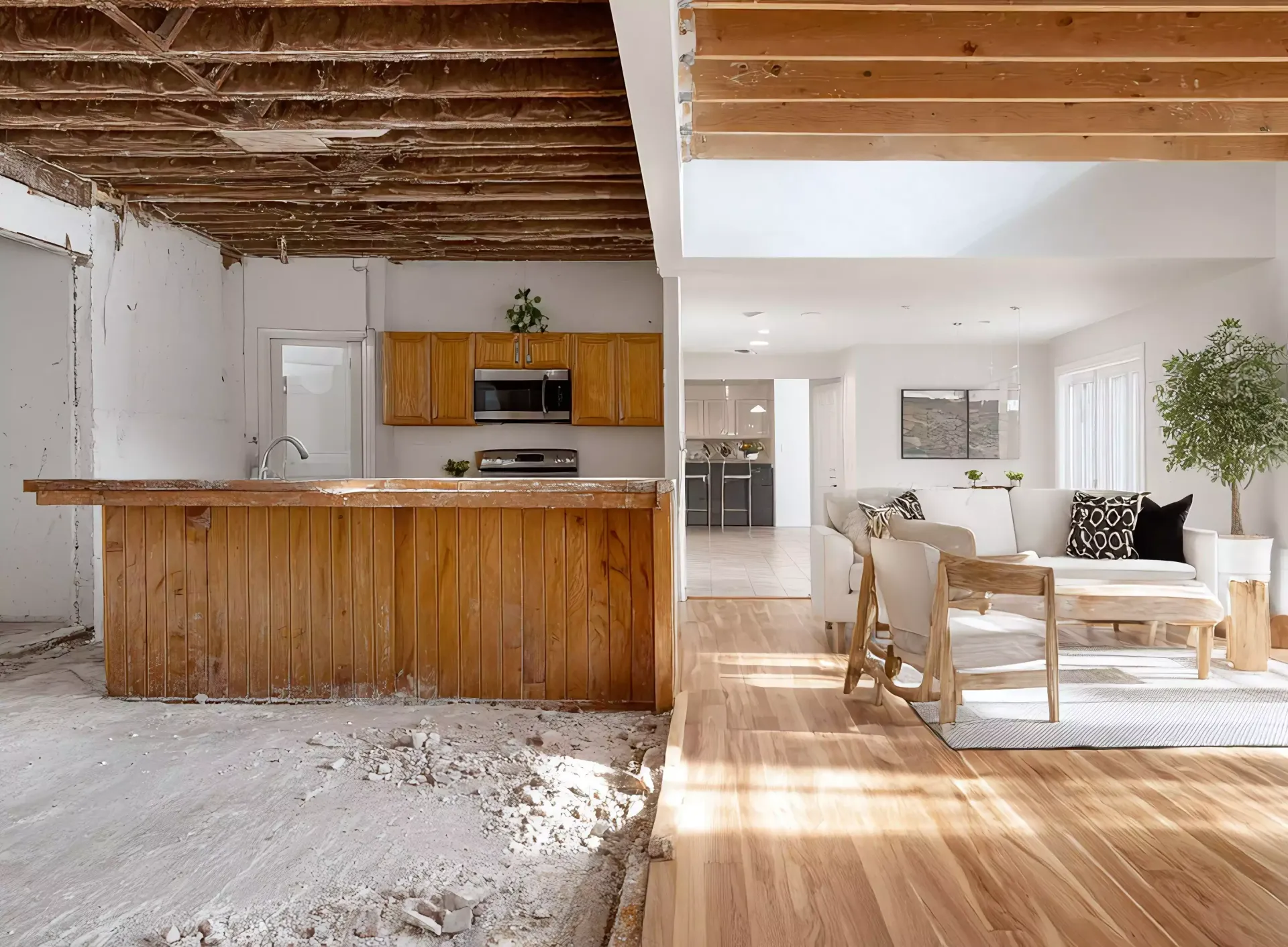 Renovated kitchen next to a finished living room, wooden floors.
