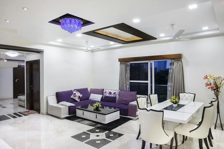 Modern living room with purple sofa, white dining table, glossy floor, and ceiling lights