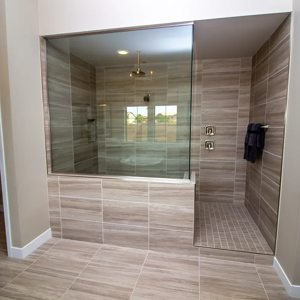 Modern tiled bathroom with glass-enclosed shower and bench seating