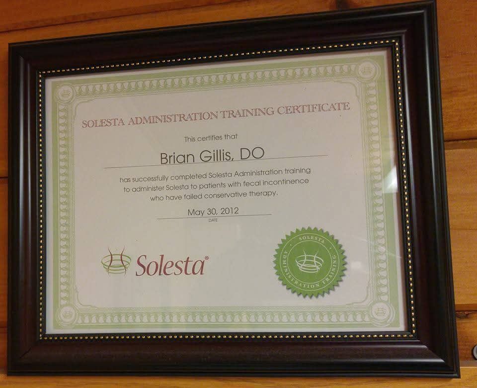 A solesta administration training certificate is framed on a wooden wall