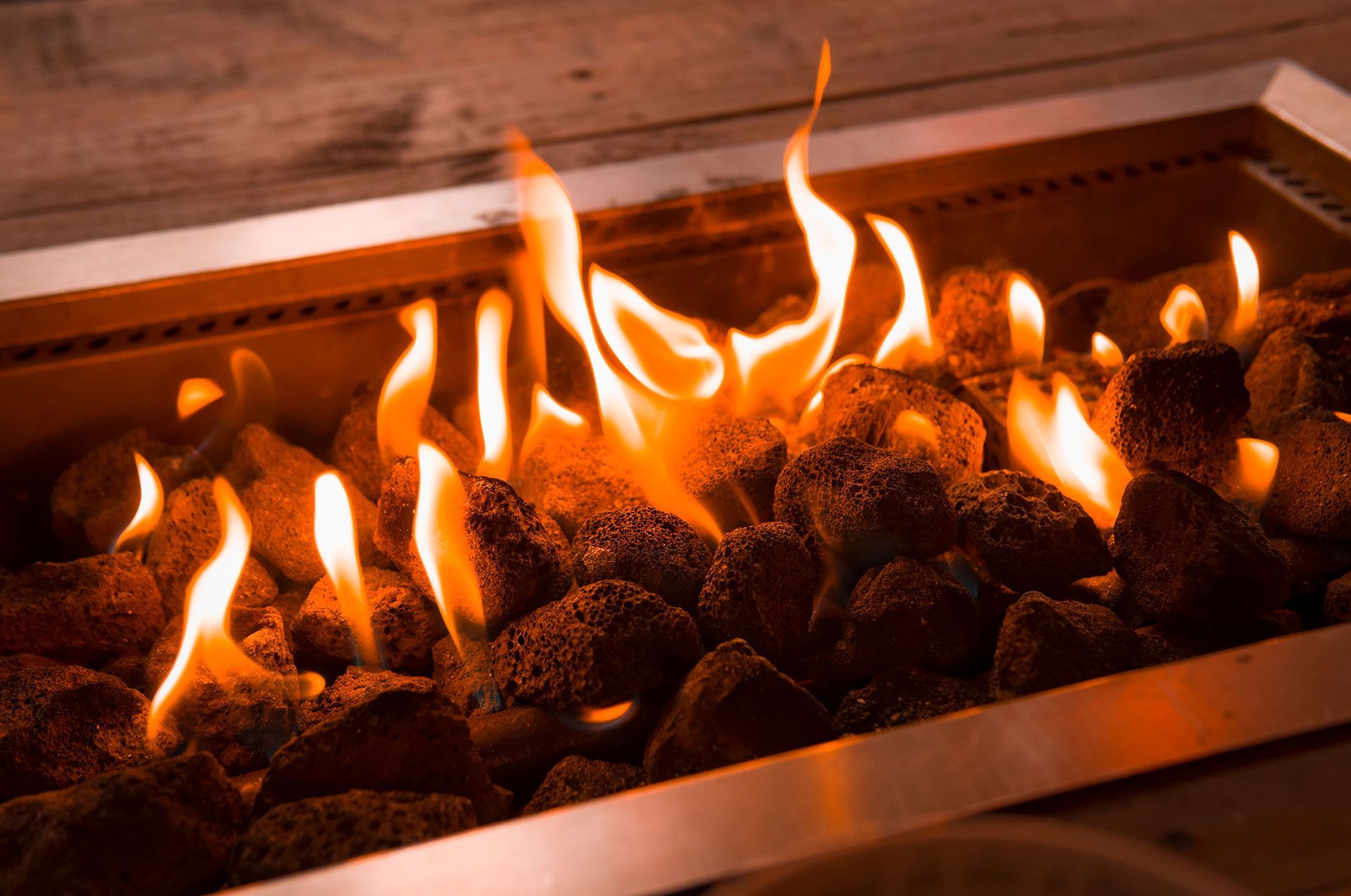 A fire pit with flames coming out of the rocks.