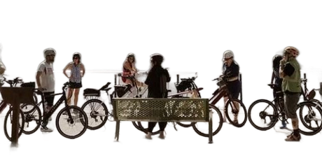 People standing with bicycles around a decorative bench in a bright outdoor setting collaborating ideas for bike tours
