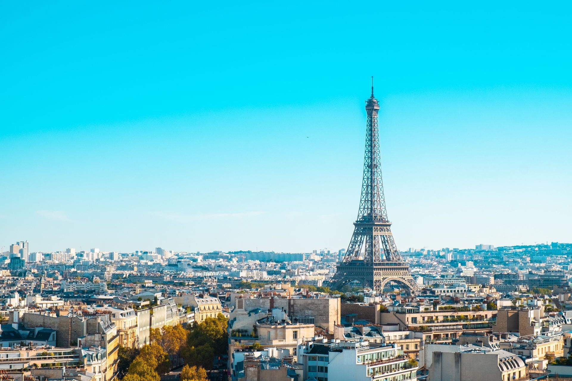 Paris skyline with the Eiffel Tower under a bright blue sky