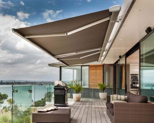 A balcony with a large awning over it and a view of the ocean.