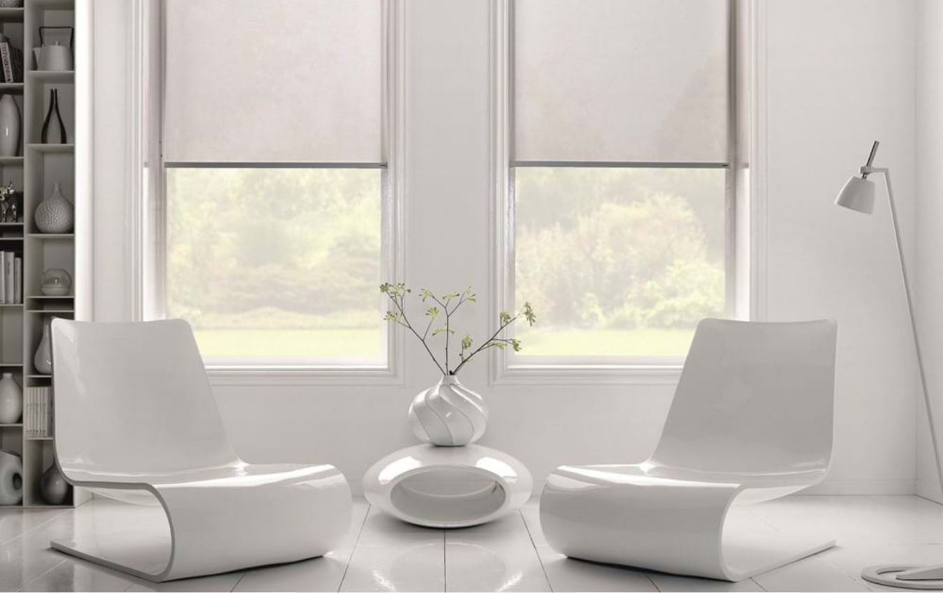 A living room with two white chairs and a vase of flowers and blinds