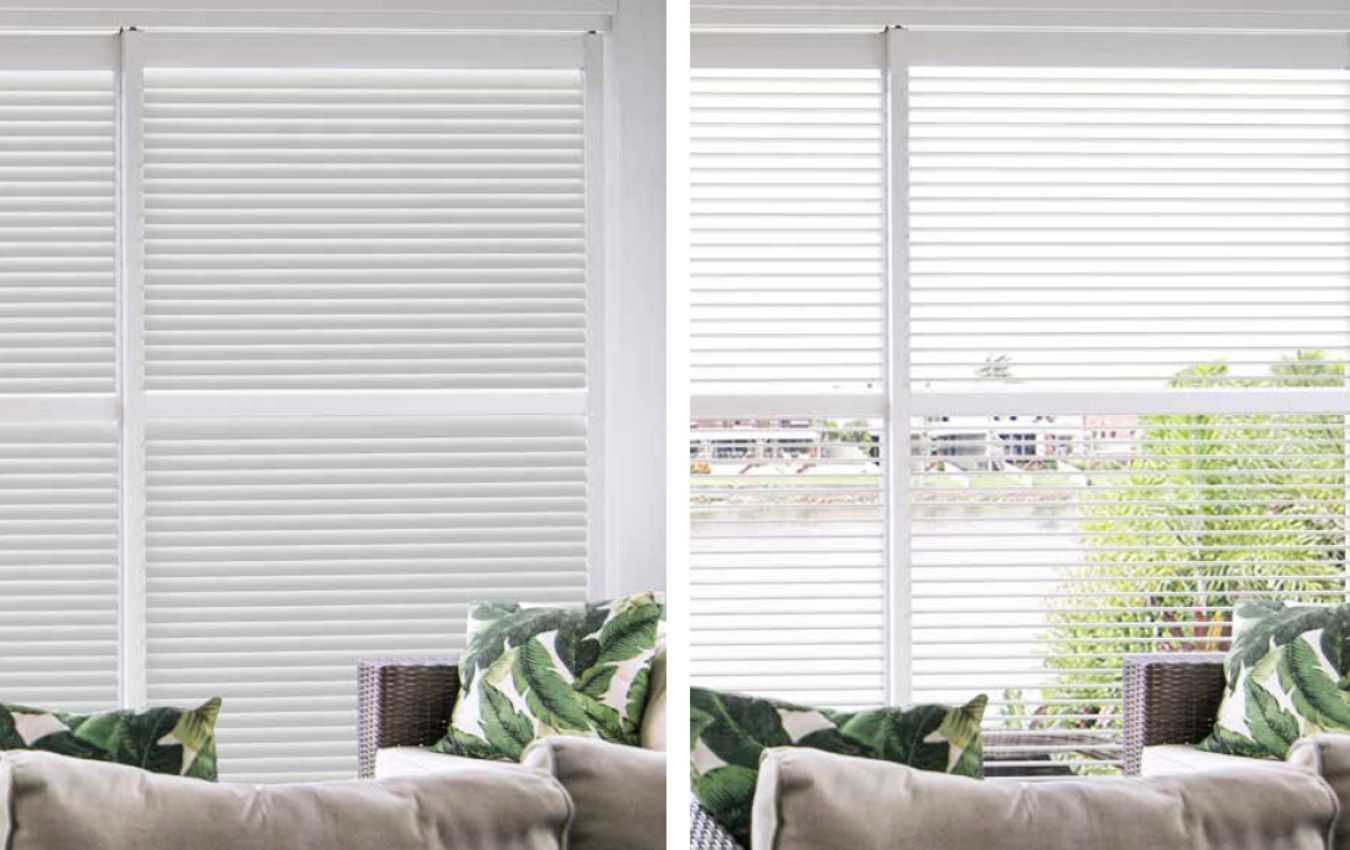 A living room with a couch and a window with blinds on it.