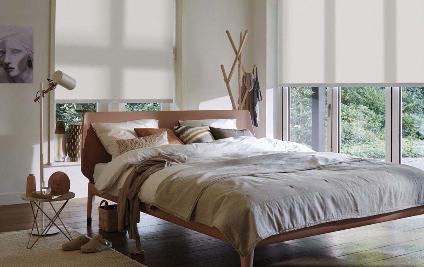 A bedroom with a bed , a lamp , and a painting on the wall and window blinds